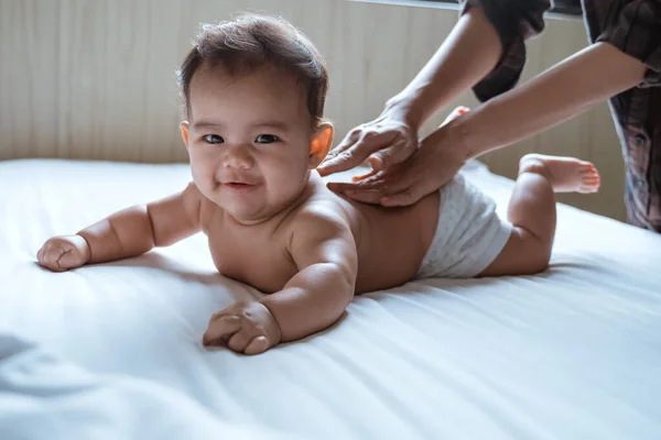 Prone baby happy is smile his back by his mother — Stock Photo, Image