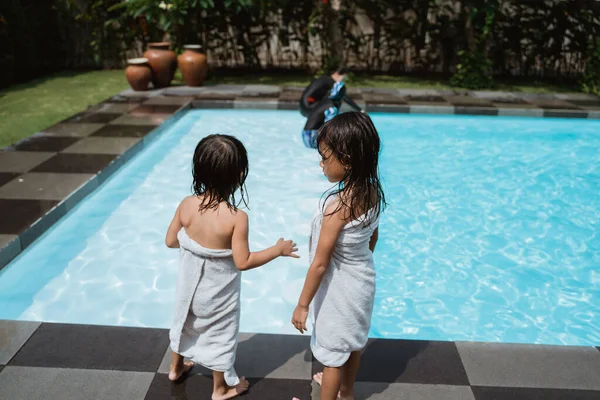 Deux petites filles portent des serviettes au bord de la piscine — Photo