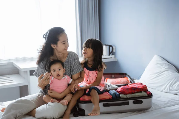 Asijské matka chatuje se svými dvěma dětmi po dokončení přípravy kufru — Stock fotografie