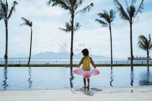 Girl wearing a buoy a child is standing by the pool — Stock Photo, Image