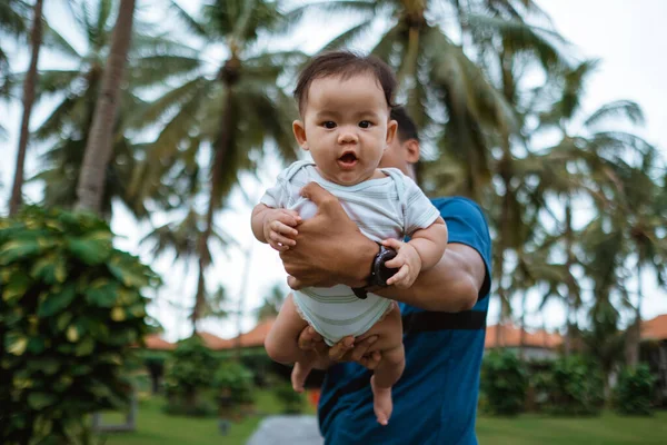 赤ちゃんを屋外に運ぶ父親は — ストック写真