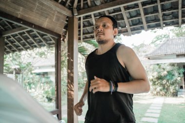 Koşu bandındaki Asyalı genç adam.