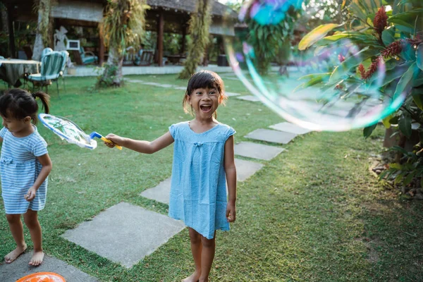 Petite fille active jouant grande bulle — Photo