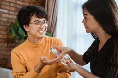 Kadın ve erkek el dezenfektanı kullanıyor.