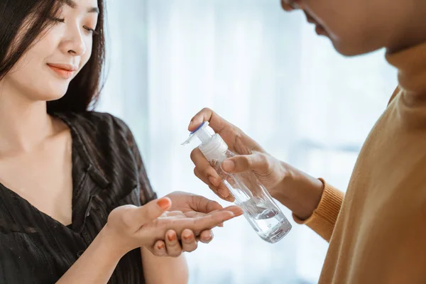 Woman and man using hand sanitizer — Stock Photo, Image