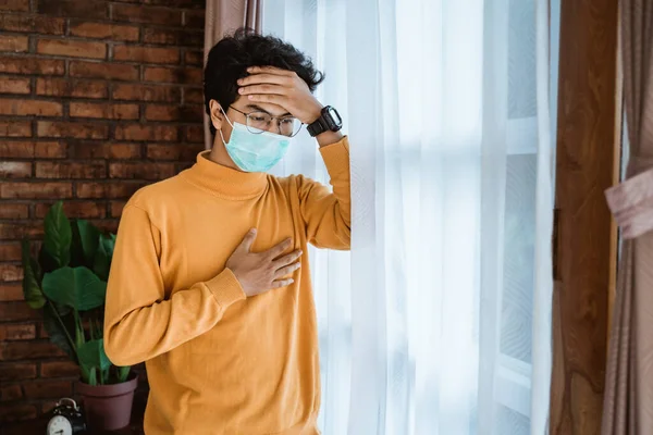 Man met gezichtsmaskers die uit het raam kijkt — Stockfoto