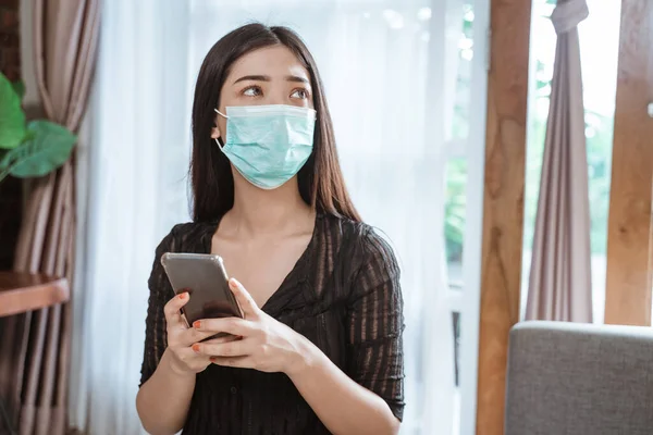 Mujer con máscaras usando el teléfono móvil para el distanciamiento social —  Fotos de Stock