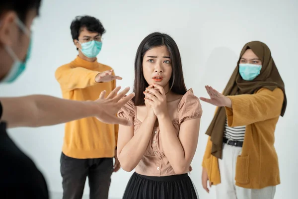 people with masks trying to touch healthy woman