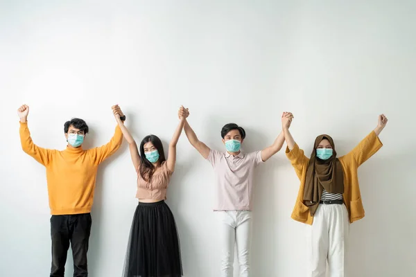 Οι άνθρωποι με μάσκες προσώπου κρατούν το χέρι — Φωτογραφία Αρχείου