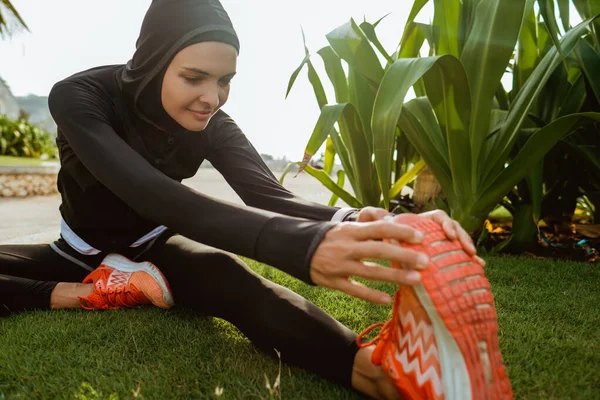 Muslimische Sportlerin streckt ihr Bein — Stockfoto