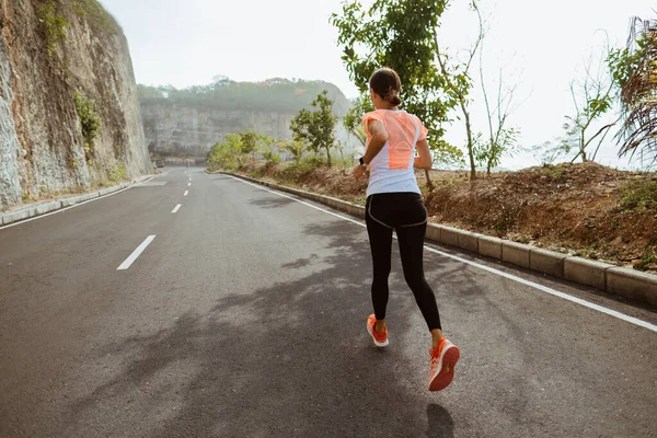 Donna sportiva in esecuzione su sideroad — Foto Stock