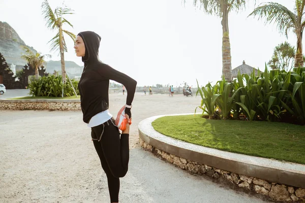 Gesunde junge muslimische Frau wärmt sich draußen auf — Stockfoto