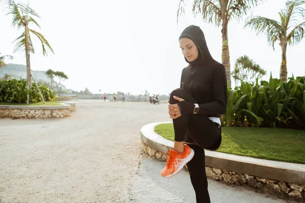 Gesunde junge muslimische Frau wärmt sich draußen auf — Stockfoto