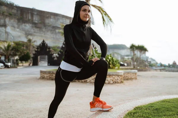 Gesunde junge muslimische Frau wärmt sich draußen auf — Stockfoto