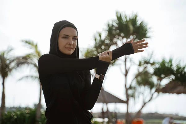 Saludable joven musulmana mujer calentando al aire libre — Foto de Stock