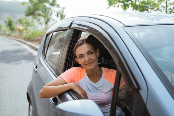 Женщина улыбается, сидя в машине — стоковое фото