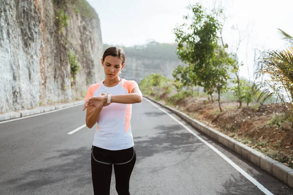 Mujer ajuste smartwatch antes de trotar —  Fotos de Stock