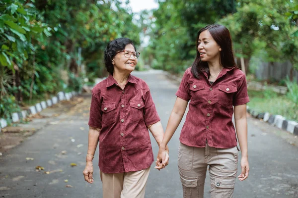 Азиатская бабушка наслаждается беседой со своими дочерьми во время ходьбы — стоковое фото