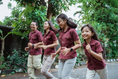 Aile dışarı koşuyor, gülümsüyor ve hafta sonunun tadını çıkarıyor.