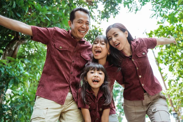 Gioioso di asiatico famiglia e loro due figlia con sollevato mani — Foto Stock