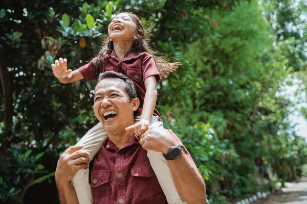 Vrolijke vader met een glimlachende nek dochter — Stockfoto