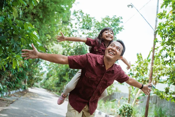 딸에게 등받이를 주는 아시아의 젊은 아버지 — 스톡 사진