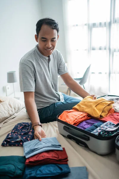 Jovem preparando suas roupas colocar na mala — Fotografia de Stock