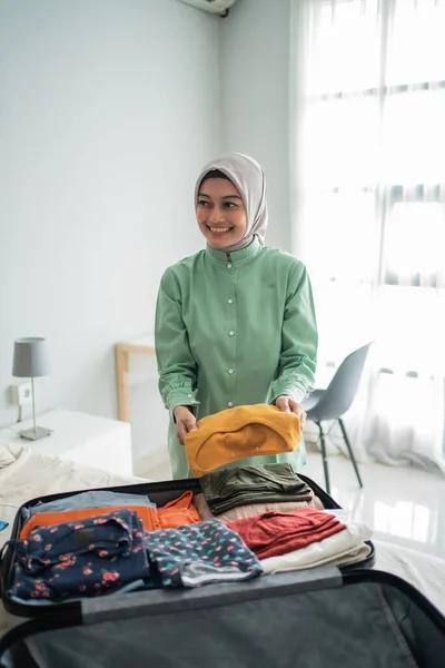 Hermosas mujeres musulmanas que preparan ropa para ponerla en una maleta — Foto de Stock