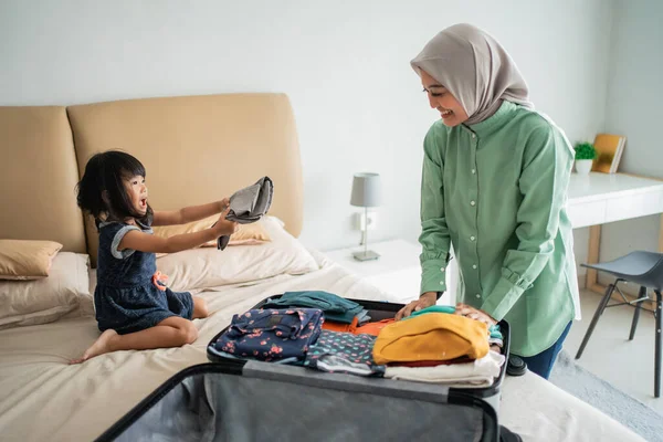 Asiática mãe muçulmana ajudou sua filha a preparar roupas — Fotografia de Stock