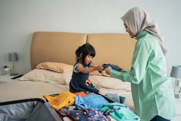 Asijské muslimské matka pomohla její dcera připravit oblečení — Stock fotografie