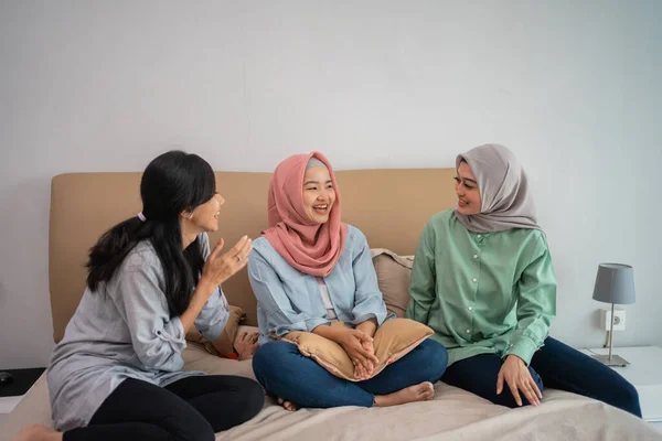 Tři asijské ženy sedí na posteli chatování — Stock fotografie