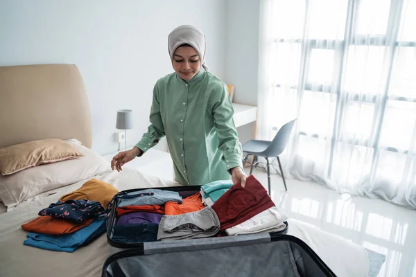 Muslimische Frauen mit Hijabs bereiten Kleidung für den Koffer vor — Stockfoto