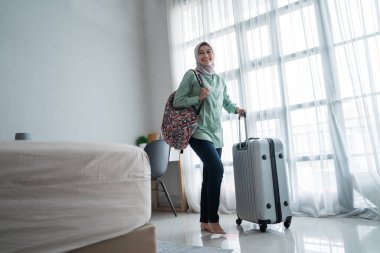 Güzel genç tesettür yolcusu çantasını taşıyor ve taşıyor.