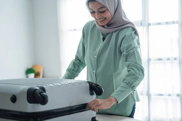 Schöne muslimische Frauen versuchten, ihren vollen Koffer zu schließen — Stockfoto