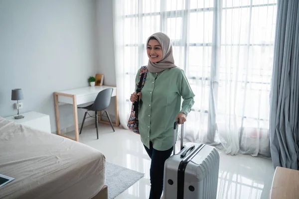 Красива молода хіджаб мандрівник ходить і несе свою сумку і тримає валізу — стокове фото