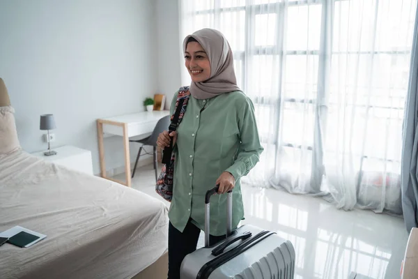 Glimlachende jonge hijab reiziger dragen haar tas en het houden van koffer — Stockfoto