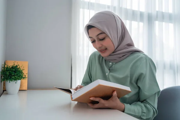 Örtülü genç kadın Kuran 'ın kutsal kitabını tutuyor. — Stok fotoğraf