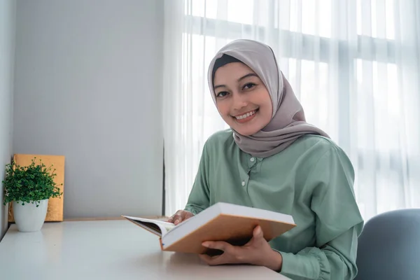 Krásná mladá žena s hidžábským úsměvem drží svatou knihu Koránu — Stock fotografie