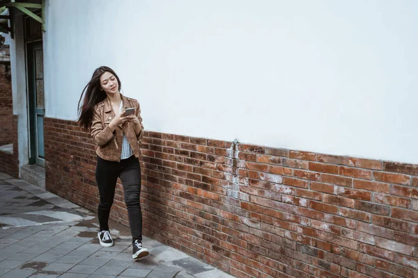 길을 걷고 있는 여자가 전화를 하고 있다 — 스톡 사진