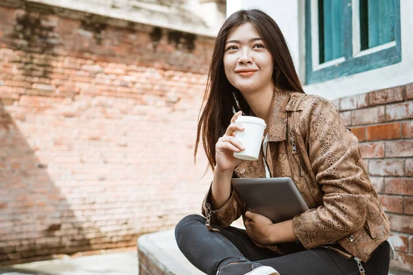 Vrouw zitten en genieten van koffie tijdens het werken buiten — Stockfoto