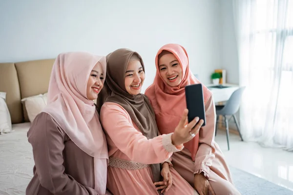 Tres mujer con velo usando teléfono inteligente para fotos —  Fotos de Stock