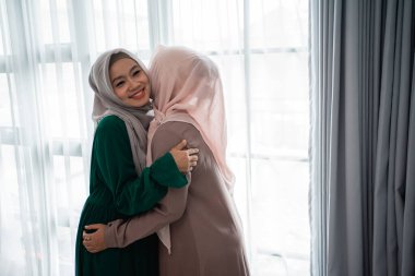 Peçeli kadın buluşurken kız kardeşine sarılır ve onu öper.