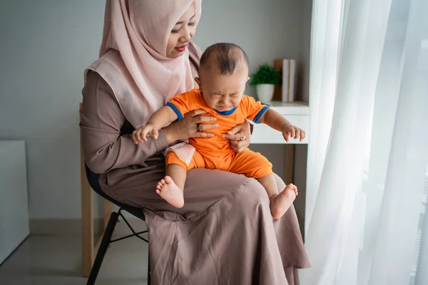 Ibu menggendong anaknya di pangkuan ketika menangis sambil duduk di kursi — Stok Foto