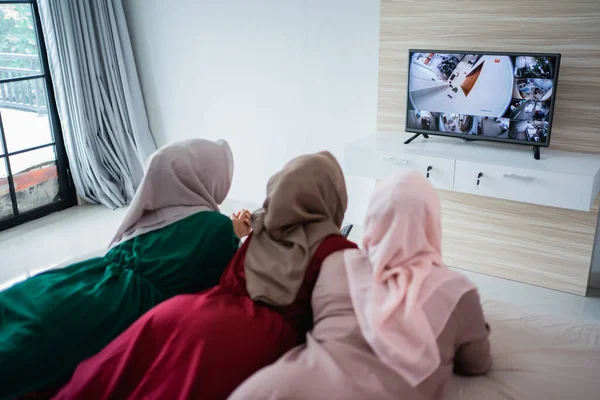Três mulher velada deitada na cama desfrutar assistindo a tv — Fotografia de Stock