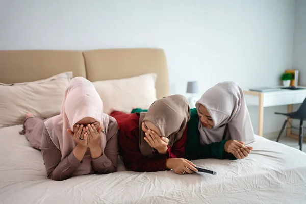 Asiática hijab mujer con amigos cubrir la cara debido a miedo al ver horor película — Foto de Stock