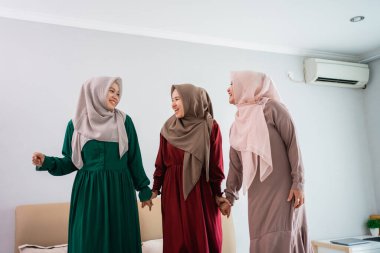 Üç Müslüman kadın yatakta dikilirken eğleniyorum.