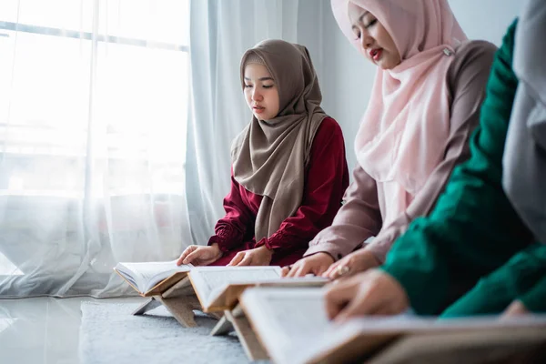 Trois musulmanes asiatiques lisent et apprennent ensemble le livre saint d'Al-Coran — Photo