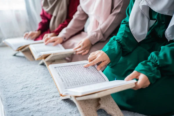 Três jovens mulheres vestindo hijabs ler o livro sagrado do Alcorão juntos — Fotografia de Stock