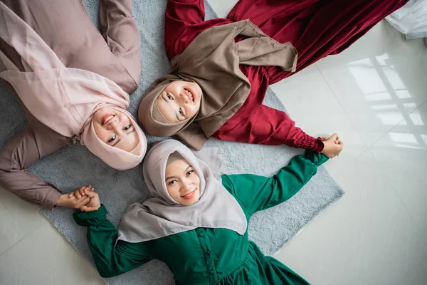 Три женщины хиджаба улыбнулись, когда лежали на матрасе — стоковое фото