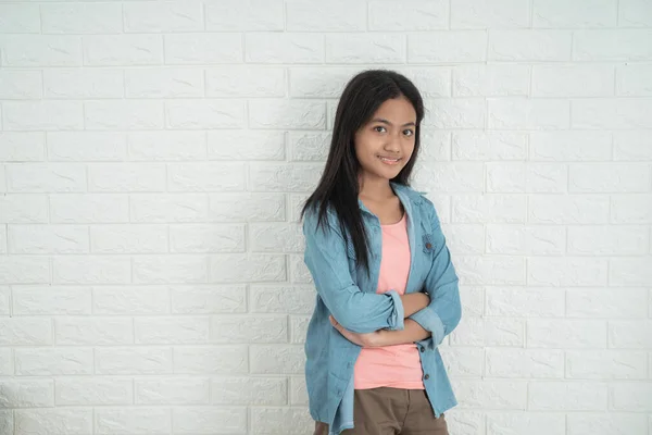 Азиатская девочка подросток, стоящая напротив белой стены — стоковое фото